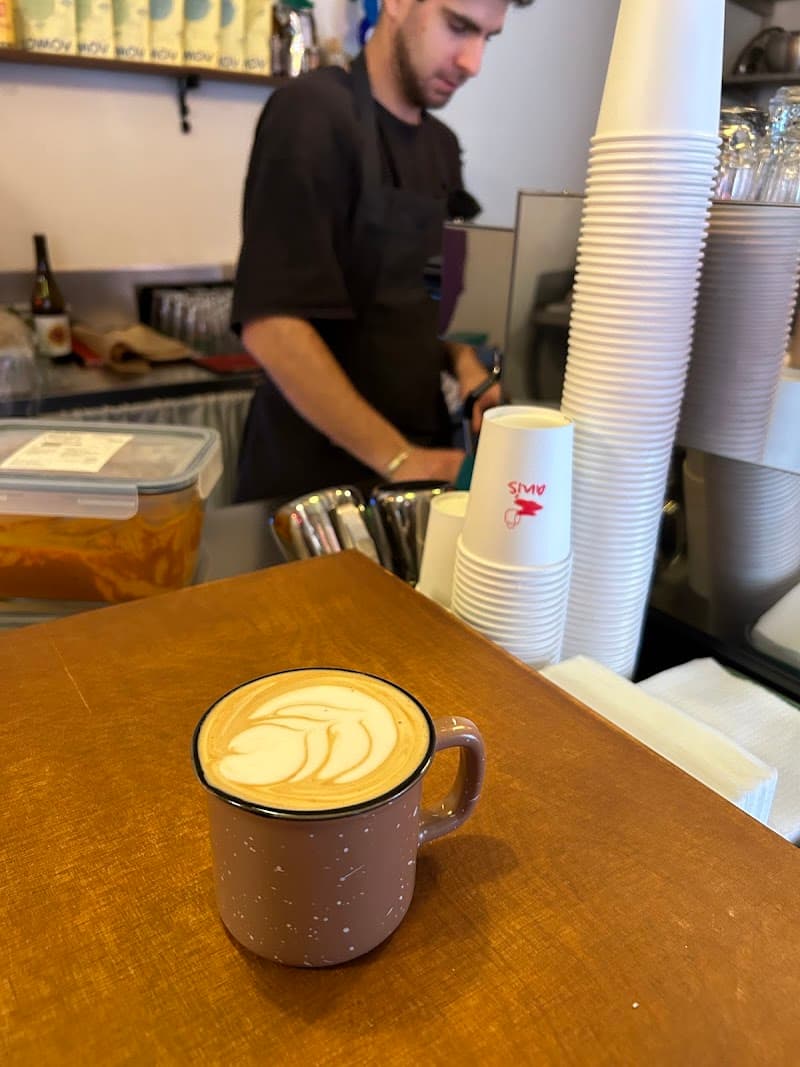 Barista preparing latte art at Café Anis